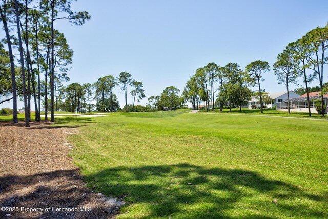 surrounding community featuring view of golf course and a yard