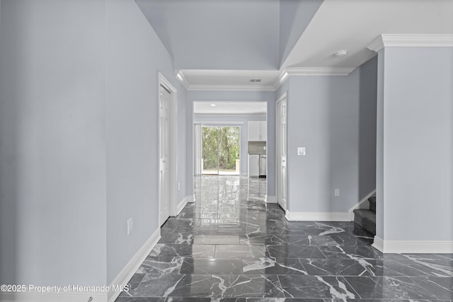 corridor featuring ornamental molding, marble finish floor, and baseboards