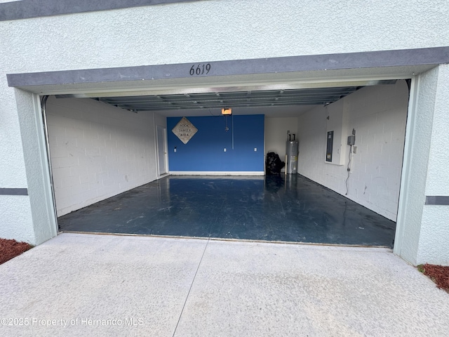garage with concrete driveway, electric water heater, and electric panel