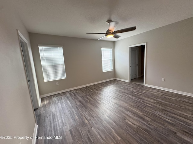 unfurnished bedroom with a ceiling fan, baseboards, dark wood finished floors, and a textured ceiling