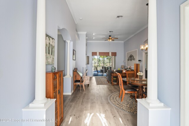 interior space featuring light wood-type flooring, visible vents, ornamental molding, decorative columns, and ceiling fan