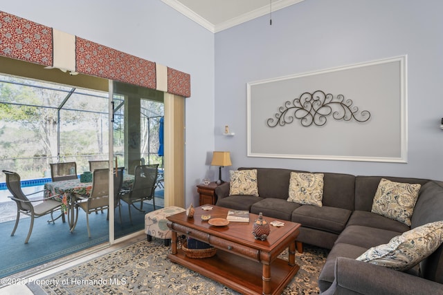 living room with crown molding, a towering ceiling, and wood finished floors