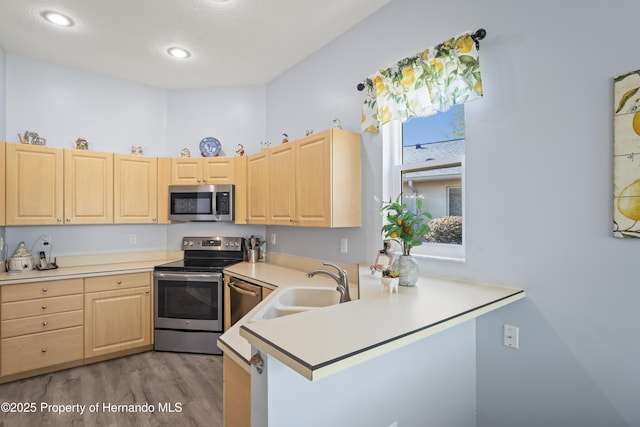 kitchen featuring light brown cabinetry, appliances with stainless steel finishes, light countertops, and wood finished floors