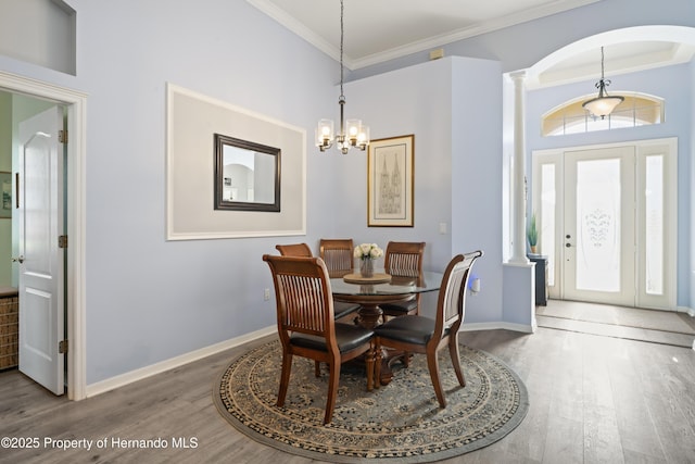 dining area with crown molding, baseboards, and wood finished floors