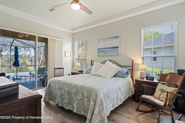 bedroom with access to exterior, visible vents, ceiling fan, and wood finished floors