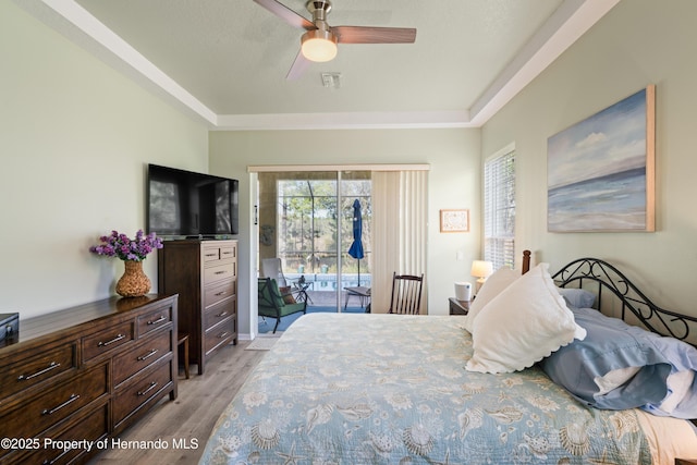 bedroom featuring light wood finished floors, visible vents, ceiling fan, and access to outside