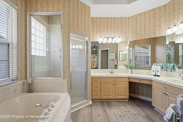 full bathroom with wallpapered walls, wood finished floors, a stall shower, and a sink