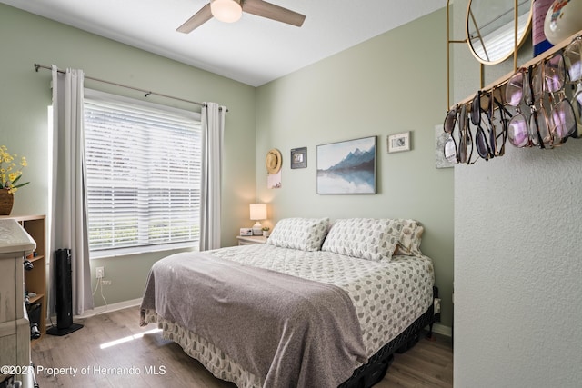 bedroom with baseboards, wood finished floors, and a ceiling fan