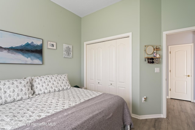 bedroom featuring wood finished floors, a closet, and baseboards