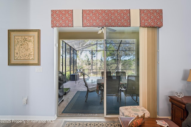 dining area featuring baseboards, a ceiling fan, and a sunroom