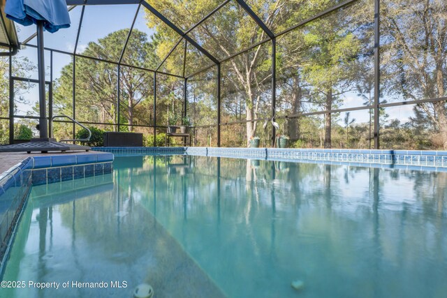 view of swimming pool with glass enclosure