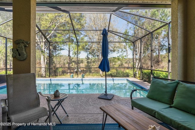 pool with a patio area, glass enclosure, and outdoor lounge area