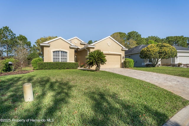 ranch-style house featuring stucco siding, an attached garage, decorative driveway, and a front lawn