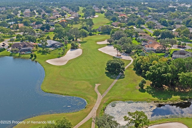 drone / aerial view featuring golf course view, a water view, and a residential view