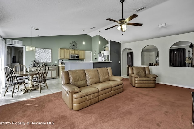 living room featuring vaulted ceiling, a textured ceiling, visible vents, and light colored carpet