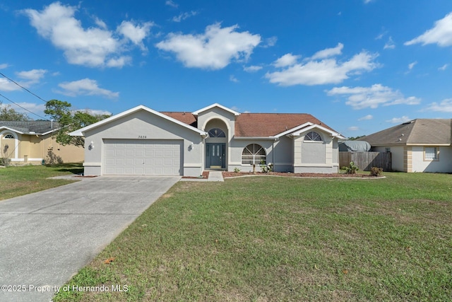 ranch-style house featuring a front yard, concrete driveway, an attached garage, and stucco siding