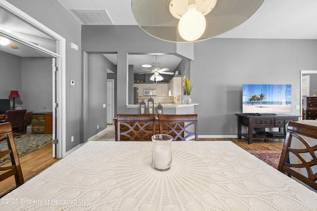 dining room with baseboards, wood finished floors, visible vents, and a ceiling fan