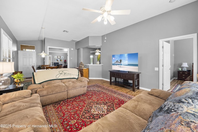 living area with lofted ceiling, a ceiling fan, baseboards, and wood finished floors