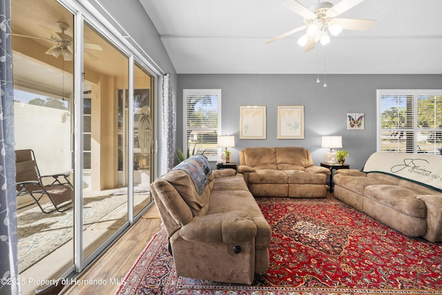 living room featuring lofted ceiling, wood finished floors, and a ceiling fan