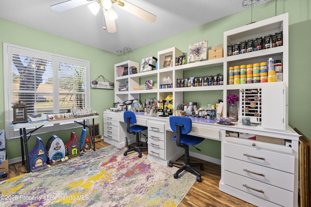 office featuring wood finished floors, a ceiling fan, and baseboards