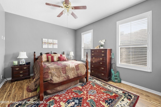 bedroom featuring wood finished floors, a ceiling fan, and baseboards