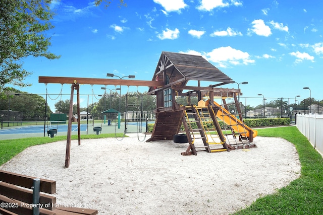 community playground featuring a tennis court and fence