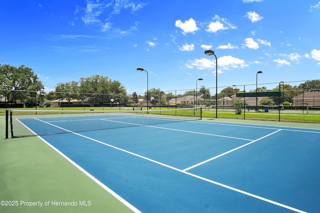 view of tennis court featuring fence