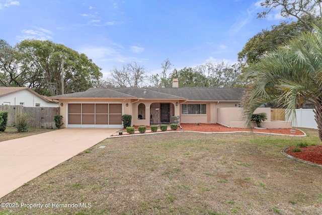 ranch-style home featuring concrete driveway, fence, an attached garage, and stucco siding