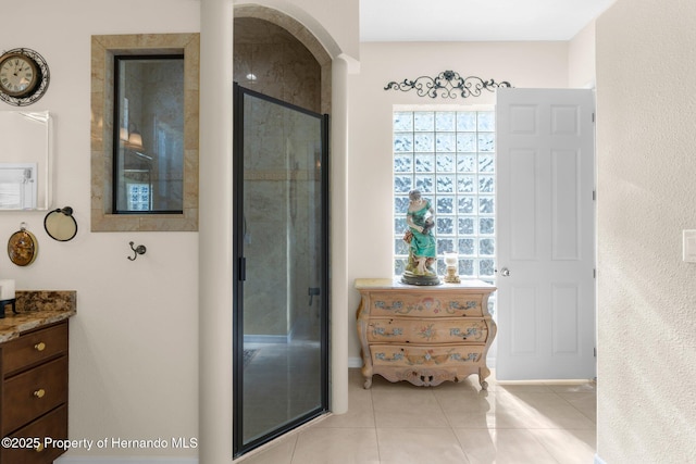 full bath with tile patterned floors, vanity, and a stall shower