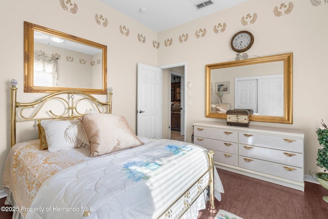 bedroom with visible vents and wood finished floors