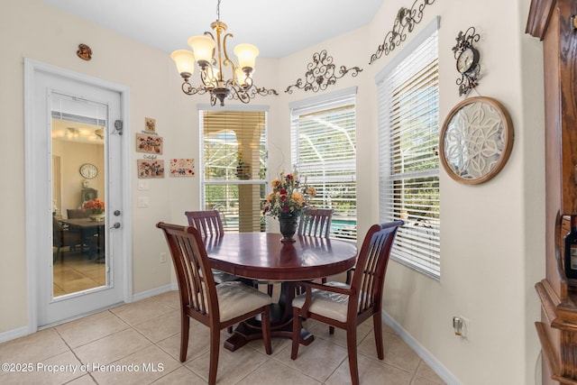 dining area with light tile patterned floors, a notable chandelier, and baseboards