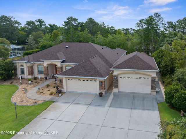 view of front of home with roof with shingles, stone siding, driveway, a garage, and stucco siding