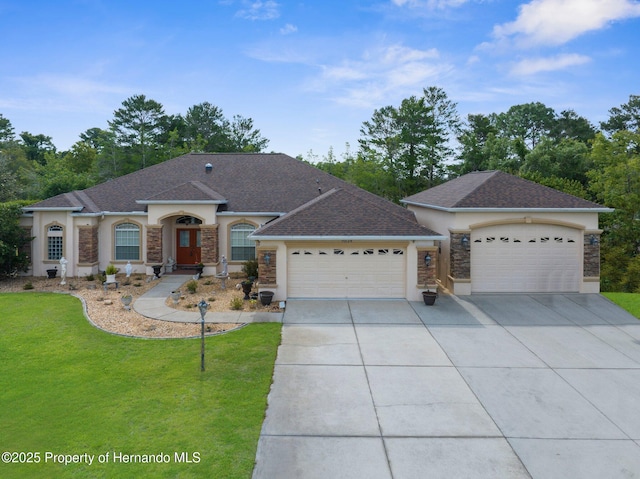 ranch-style home with stone siding, a garage, stucco siding, concrete driveway, and a front lawn