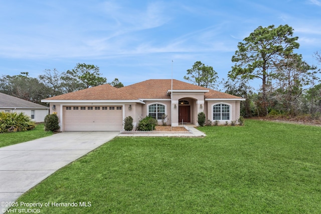 mediterranean / spanish house featuring a garage, concrete driveway, a front lawn, and stucco siding