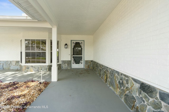 view of exterior entry featuring brick siding