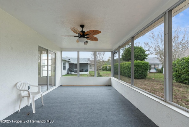 unfurnished sunroom featuring ceiling fan