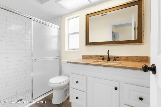 bathroom with visible vents, vanity, a shower stall, and toilet