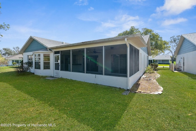 back of property with a yard and a sunroom