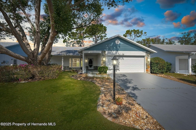 single story home with a garage, driveway, and a lawn