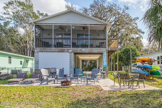 rear view of property featuring an outdoor fire pit, a lawn, a ceiling fan, a patio, and fence