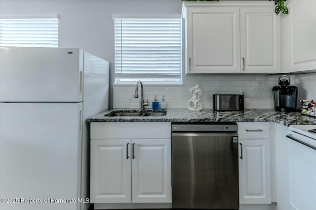 kitchen with a sink, white cabinetry, freestanding refrigerator, dishwasher, and tasteful backsplash