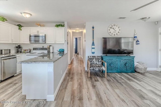 kitchen featuring light wood-style flooring, visible vents, white cabinets, appliances with stainless steel finishes, and decorative backsplash