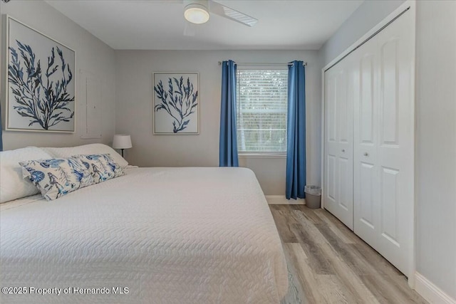 bedroom featuring a ceiling fan, light wood-type flooring, a closet, and baseboards