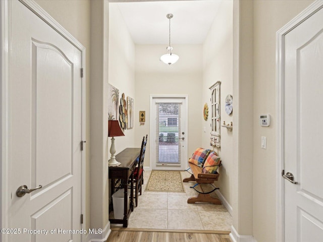 entryway with light wood-type flooring and baseboards