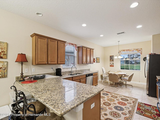 kitchen featuring a breakfast bar area, visible vents, appliances with stainless steel finishes, a sink, and a peninsula