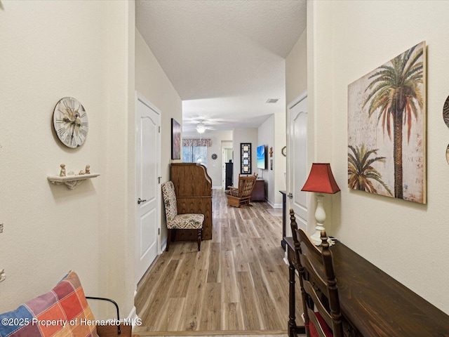 hall featuring light wood-type flooring and baseboards