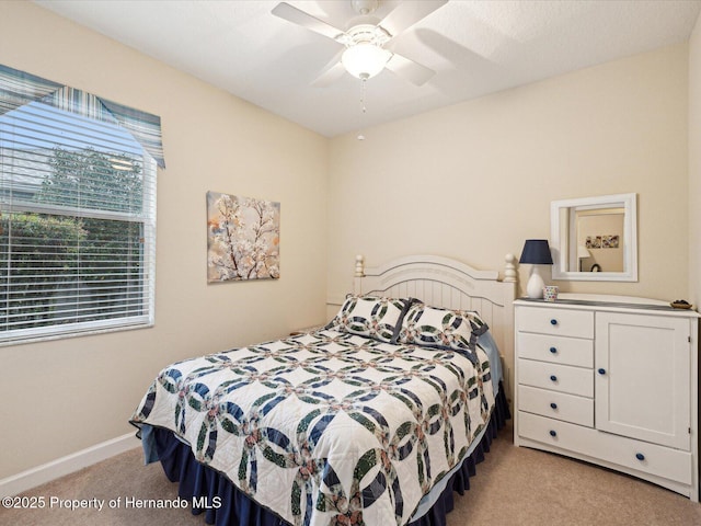 bedroom featuring light colored carpet, ceiling fan, and baseboards