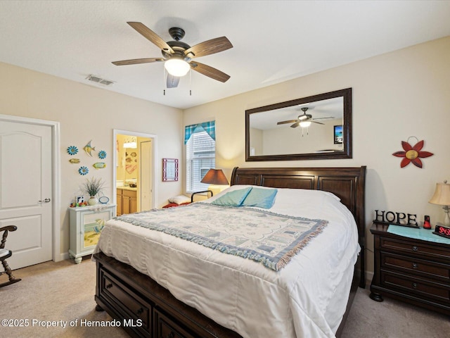 bedroom with light carpet, visible vents, a ceiling fan, and ensuite bathroom