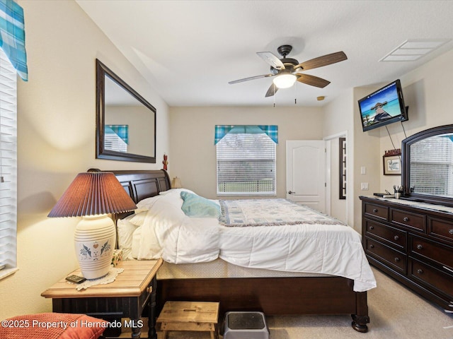 bedroom featuring light carpet and a ceiling fan