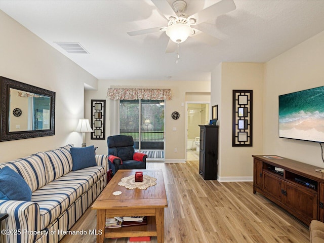 living room featuring light wood-type flooring, baseboards, visible vents, and ceiling fan